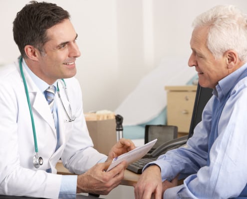 radiation oncologist talking to a senior man prior to treatment