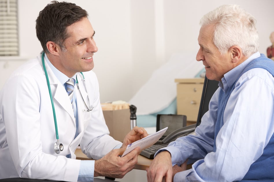radiation oncologist talking to a senior man prior to treatment
