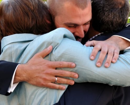 Man hugging family to celebrate cancer remission