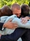 Man hugging family to celebrate cancer remission