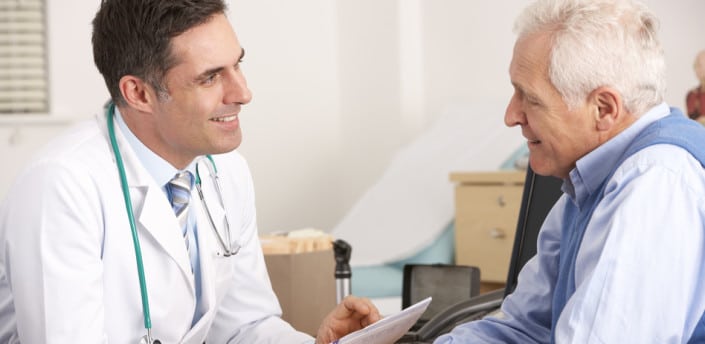 Oncologist speaking with elderly male patient