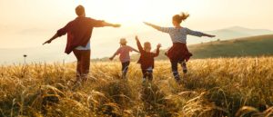 family running in field at sunset, happy the children are cured from pediatric cancer